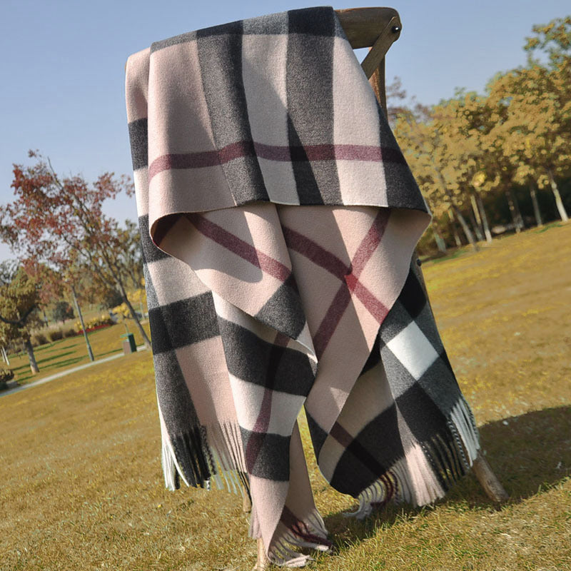 Solstik premium cozy wool scarf with large check pattern draped over a wooden chair outdoors