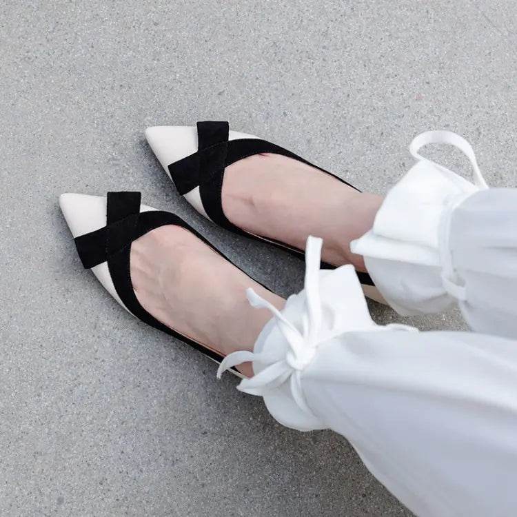 Solstik black and white pointed flats with bow detail on feet against gray background