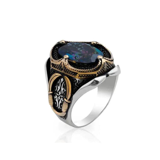Solstik bold designer cocktail ring featuring an intricate black and gold setting with a large dark gemstone