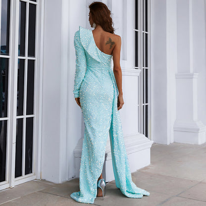 Evelyn Belluci elegant sequin dress with slit in light blue worn by woman standing indoors