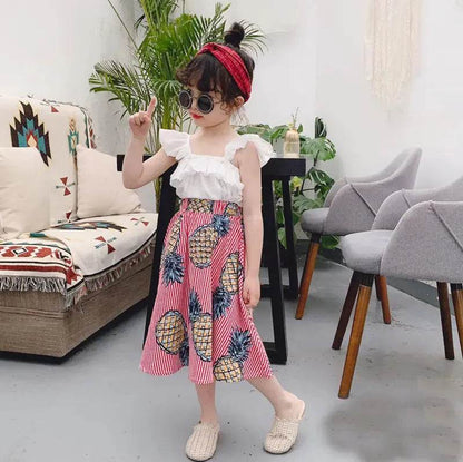 Girl wearing girls pineapple skirt and top set with white ruffled top and pink pineapple print skirt