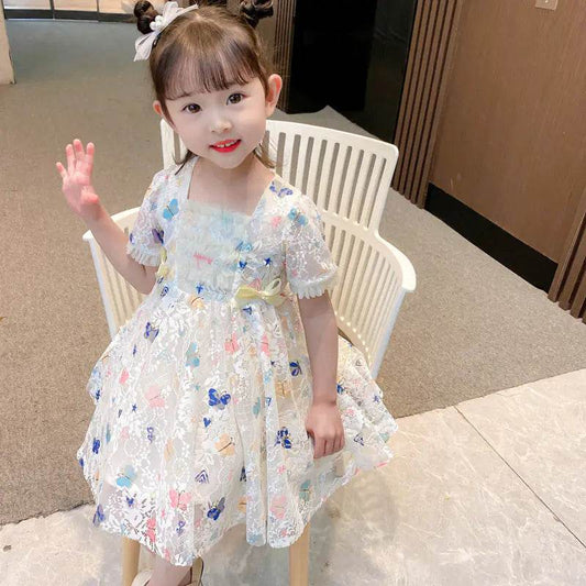 Adorable toddler wearing Solstik girls summer lace gown with floral embroidery and puff sleeves