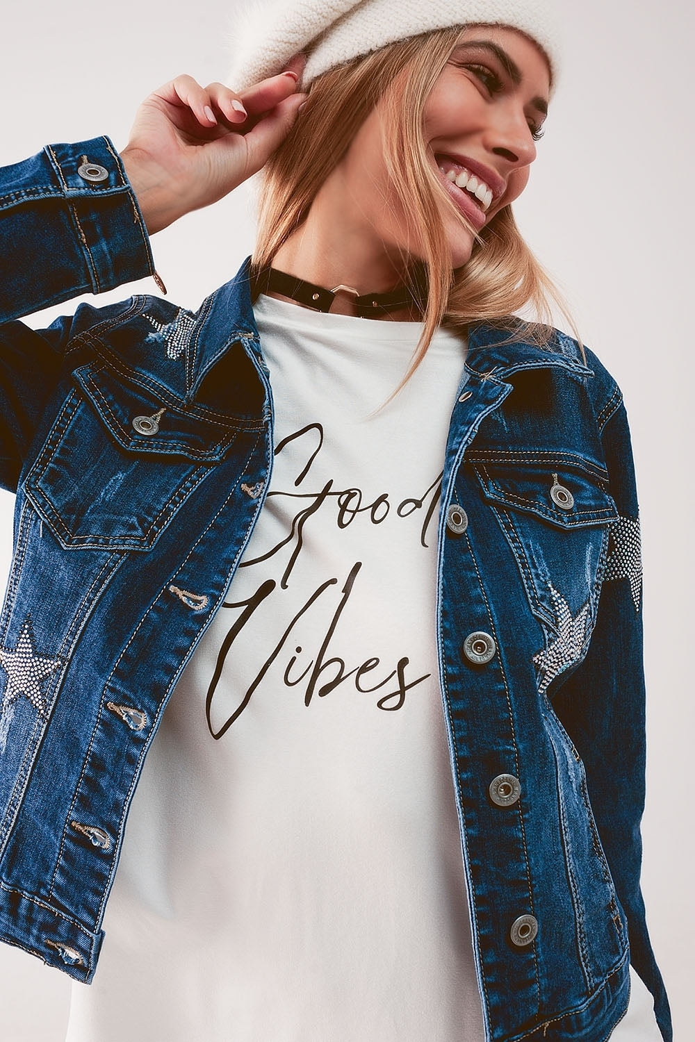 Q2 luxury women's denim outerwear jacket with star embellishments worn over white graphic top