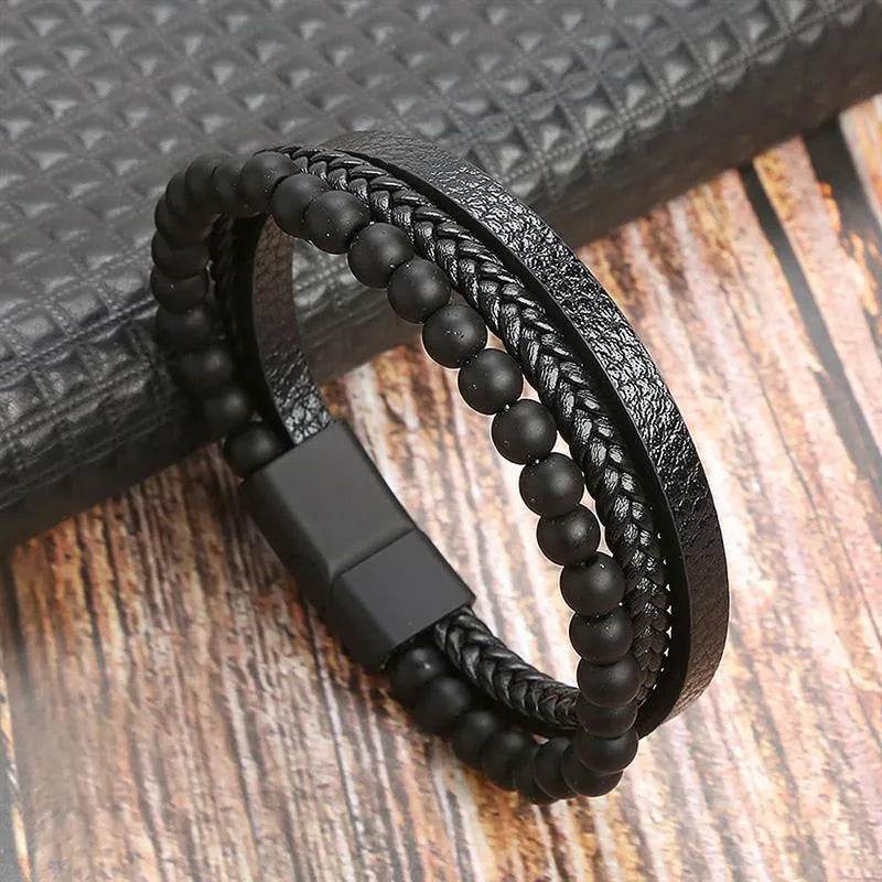 Solstik men's braided leather wristband with black beads and magnetic clasp on wooden surface