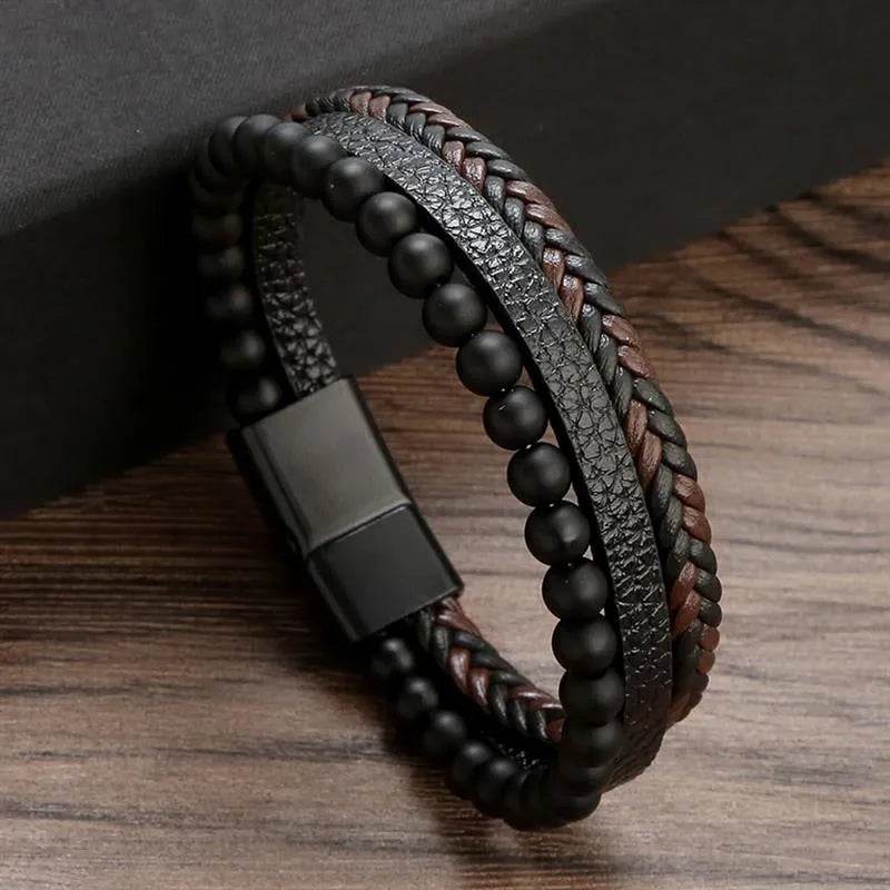 Solstik men's braided leather wristband with black beads and textured black leather on wooden surface