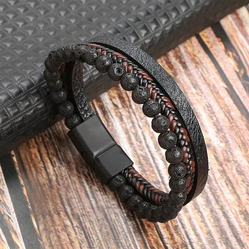 Solstik men's braided leather wristband with black lava beads and magnetic clasp on wooden surface
