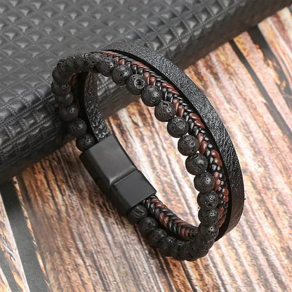 Solstik men's braided leather wristband with black lava beads and magnetic clasp on wooden surface