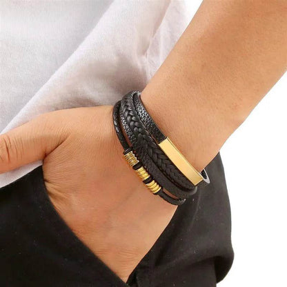 Solstik men's braided leather wristband in black with gold accents worn on wrist