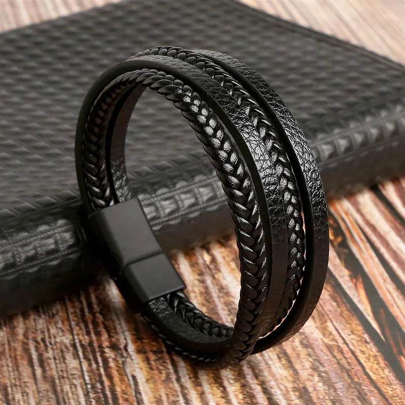 Solstik men's braided leather wristband in black with magnetic clasp on wooden surface