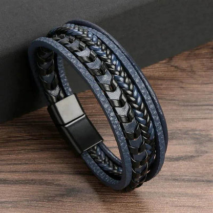 Solstik men's braided leather wristband in black and blue with magnetic clasp on wooden surface