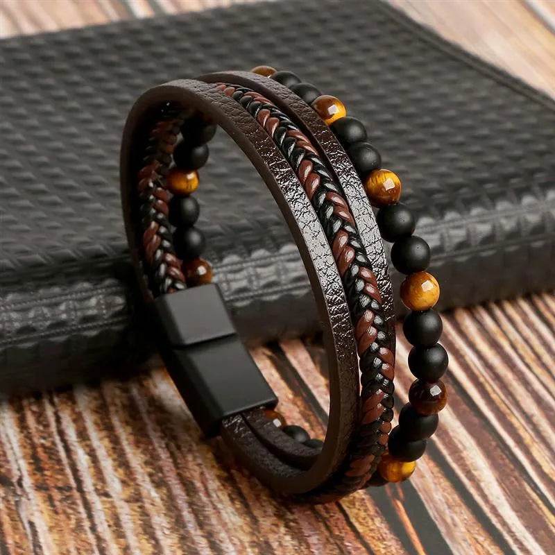 Solstik men's braided leather wristband with black and brown beads and magnetic clasp on wood surface