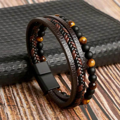 Solstik men's braided leather wristband with black and brown beads and magnetic clasp on wood surface