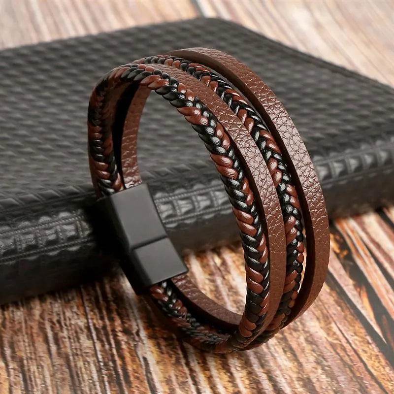 Solstik men's braided leather wristband in brown and black with magnetic clasp on wooden surface