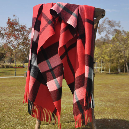 Solstik premium cozy wool scarf in red black and pink plaid draped over wooden chair outdoors