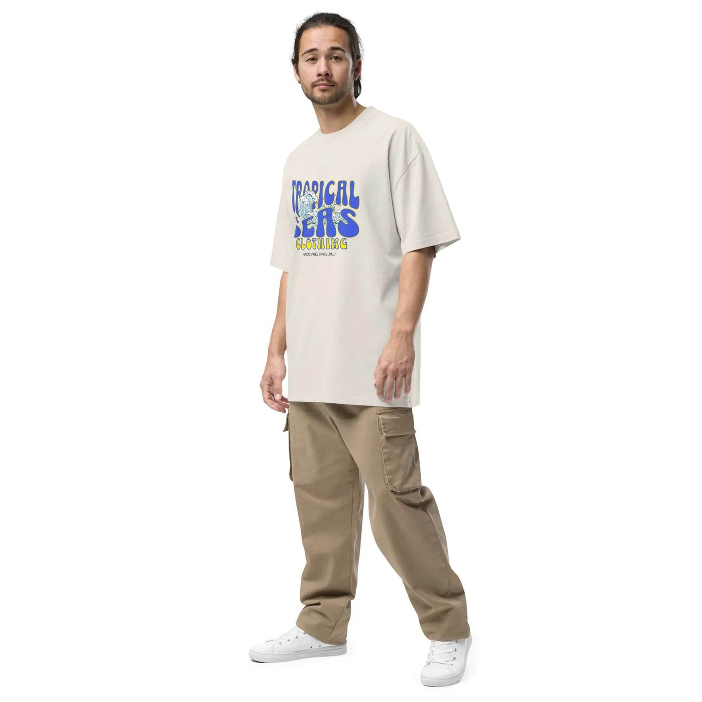 Man wearing Solstik statement oversized summer shirt with tropical seas print paired with khaki cargo pants and white sneakers
