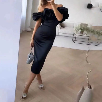 Woman wearing elegant black off shoulder dress with puff sleeves in modern living room, white chic cocktail dress